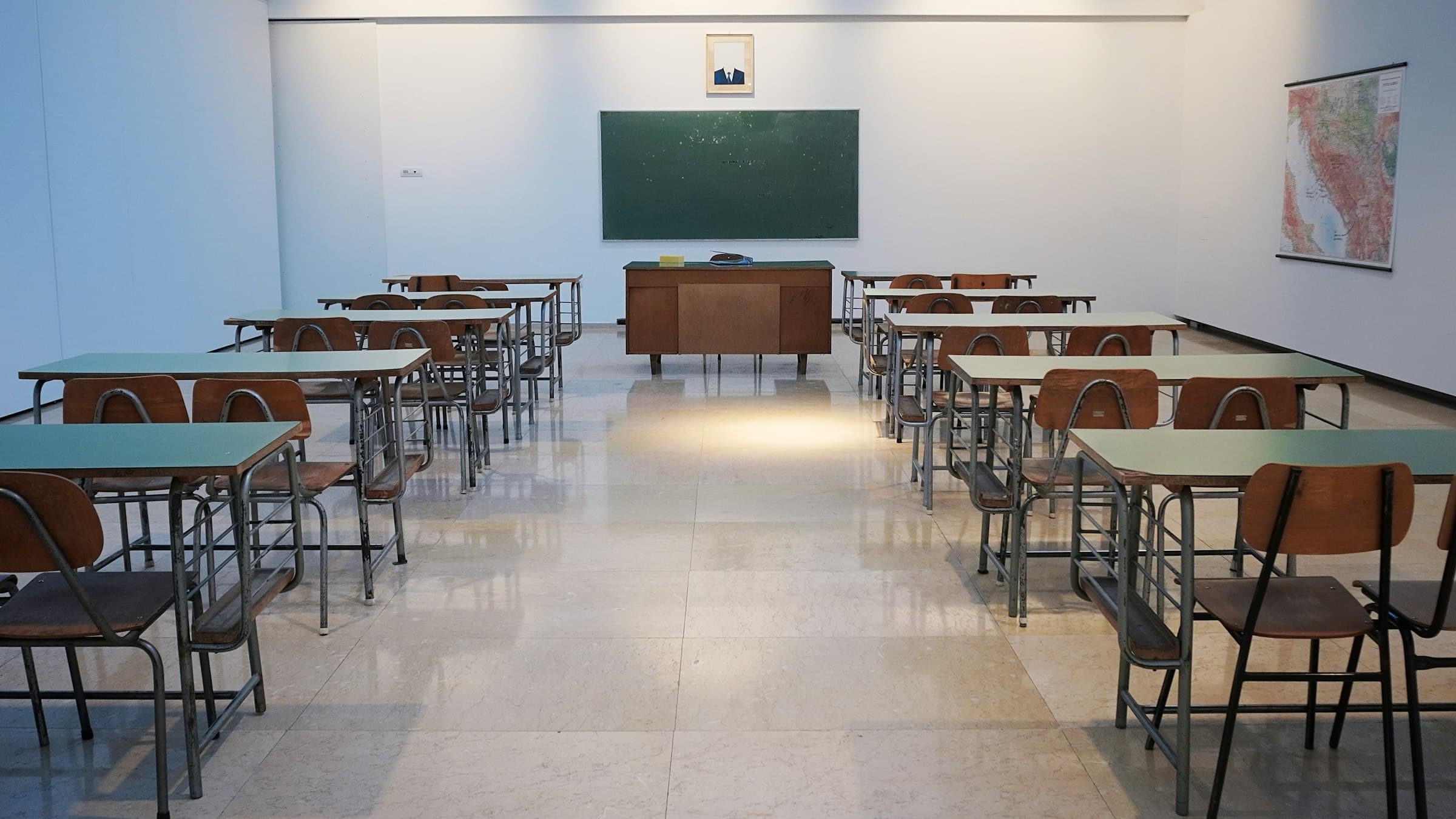 Rows of empty desks arranged in an examination hall