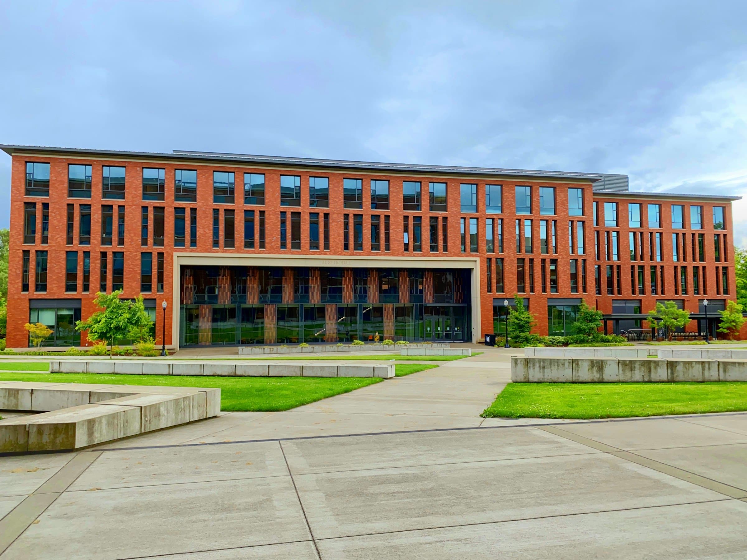 A modern brick academic building framed by lawns and walkways